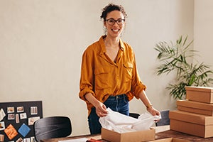 woman packing parcel boxes for customers