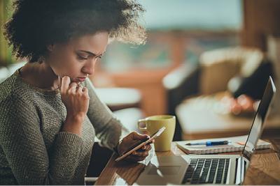 woman checking phone, laptop