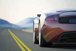 side image of fast red car going down a road