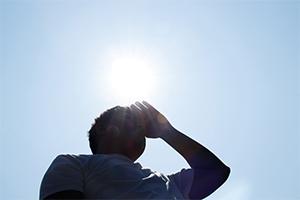 A person blocking the sun on a hot day
