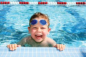Boy in the pool smiling 