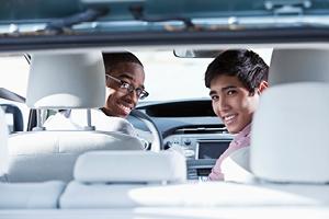 Multi-ethnic teenage boys (17 and 19 years) driving car.