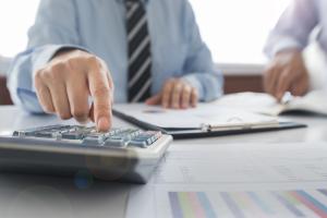 businessman entering numbers on calculator