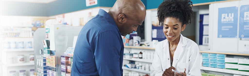 woman pharmacist explaining prescription to male customer