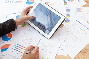 Hand holding an ipad or tablets displaying charts