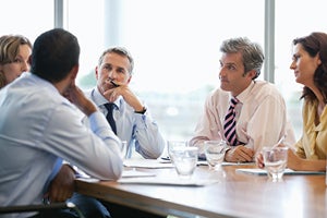 Business meeting with women and men business professional sitting at a table