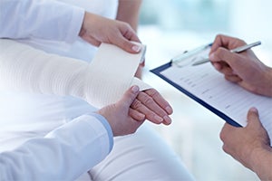 Hand being bandaged by a medical professional 