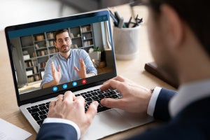 Businessman at computer attending virtual meeting