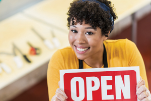 woman holding open sign