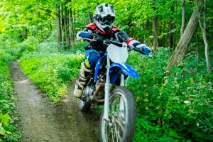 Dirt bike going down a trail in the woods