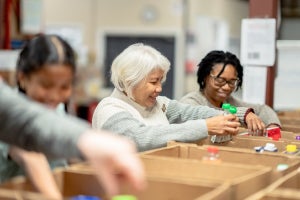 People sorting food items into cardboard boxes