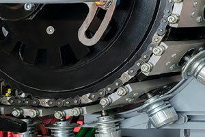 Close‑up of industrial chain‑driven machinery used in plastics manufacturing