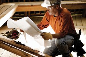 Contractor looking at plans in the midst of construction