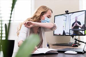 Woman covering cough with elbow