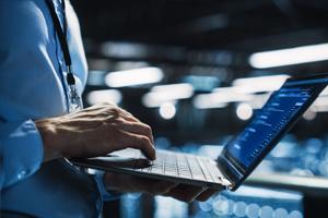 Systems integrator works on laptop