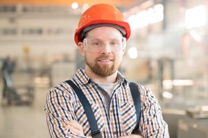Construction worker wearing orange helmet and safety glasses