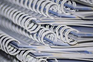 A close-up of binder rings form a stack of notebooks
