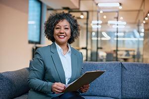 Businesswoman holding clipboard on couch
