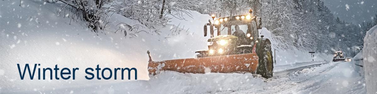 bulldozer plowing snow and text showing winter storm