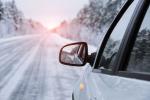 Winter road reflected in car mirror