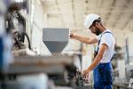 Factory worker standing at machine