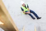 Construction worker holding knee after falling from ladder