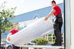 two guys moving a mattress from truck