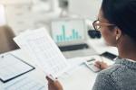 Businesswoman reading a spreadsheet at her desk