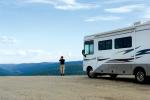 Man standing next to a camper.