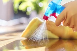 gloved hand spraying cleaner