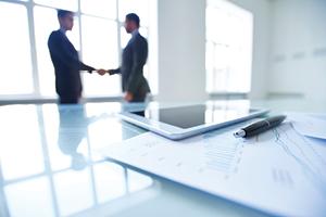 Two business men shaking hands in the distance