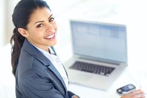 woman professional smiling sitting in front of laptop