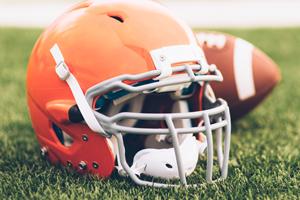football and helmet on grass