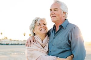 retired couple walking on the beach