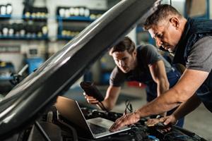 auto repair shop with two mechanics working on car