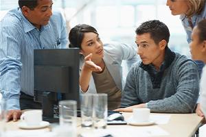 Employees collaborating in front of computer