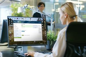 Woman in office at computer, using The Hanover's new quote and issue system