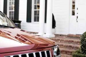 red SUV in front of a white home