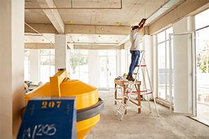 Contractor on ladder working on pipes