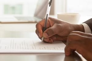 man's hands signing contract