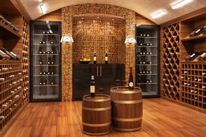 Elegant wine cellar with bottles of wine stored on their side and two barrels with bottles of wine and wine glasses on them.