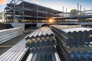 Construction site backlit by sun with metal girders in the foreground