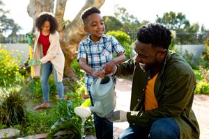 Family watering outdoors at their home